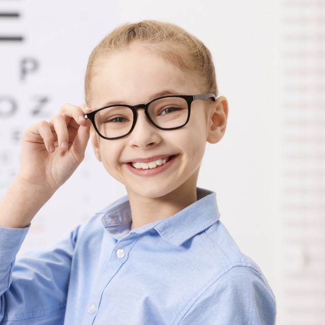 A smiling young girl wearing eyeglasses